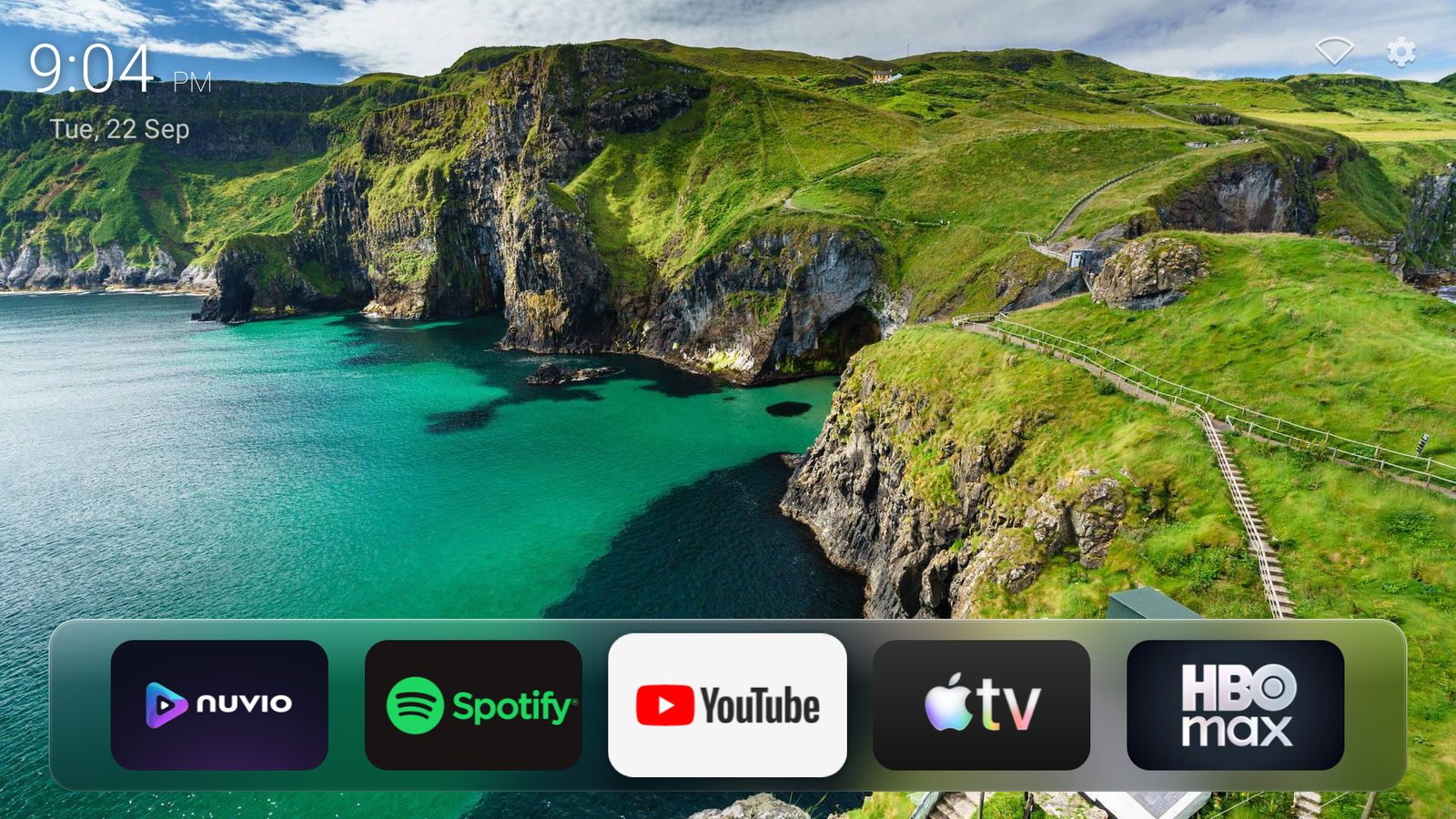Glass home screen: a clock over a coastal wallpaper, with five favorite apps on a glass shelf